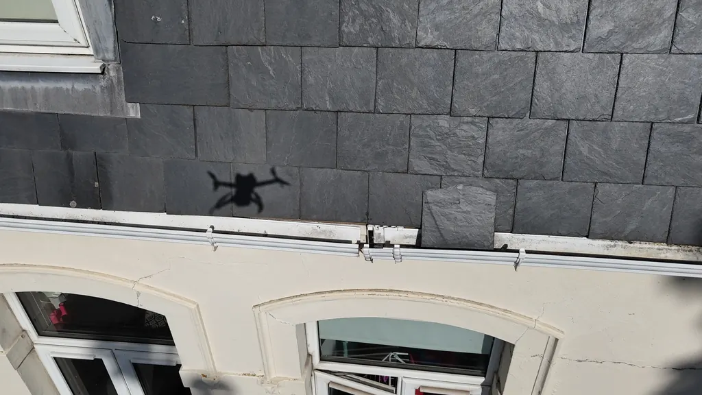 Drone inspection in Brighton: slate roof edge above a rendered facade