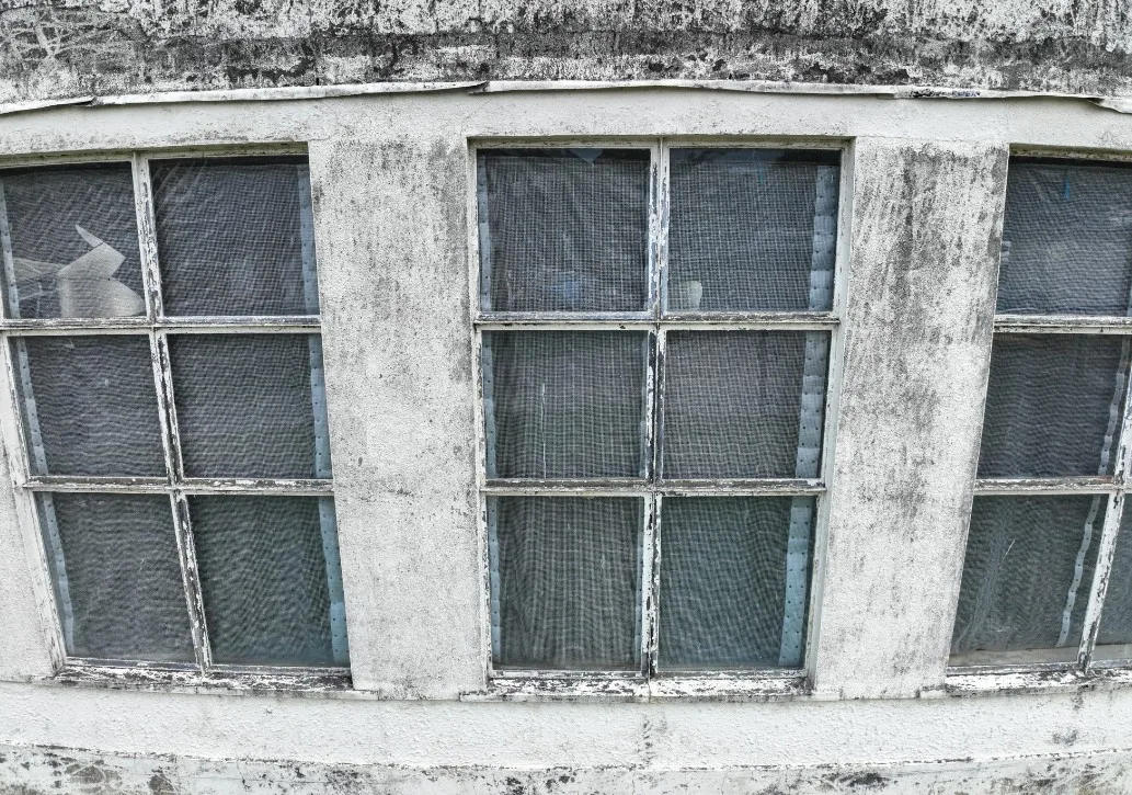 Close-up of cracked render above a window opening